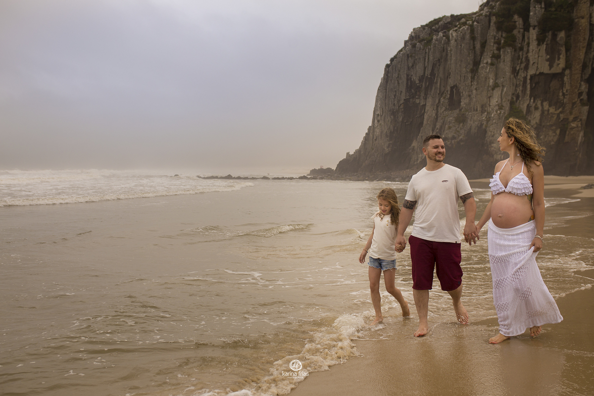 a familia esta andando no meio da agua do  mar
