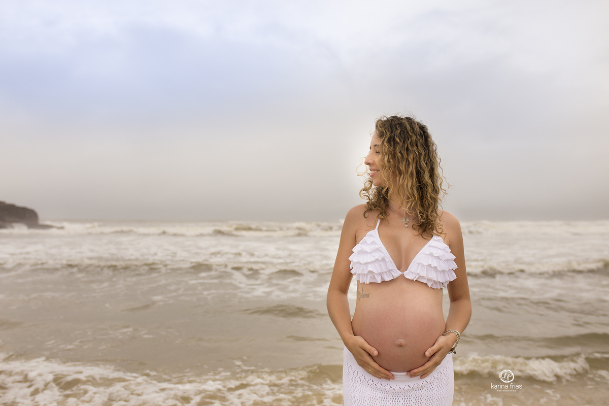 a gestante posa em frente a agua do mar