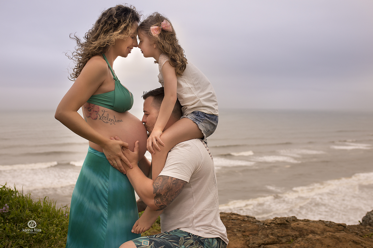 a familia troca carinhos durante o ensaio de gestante