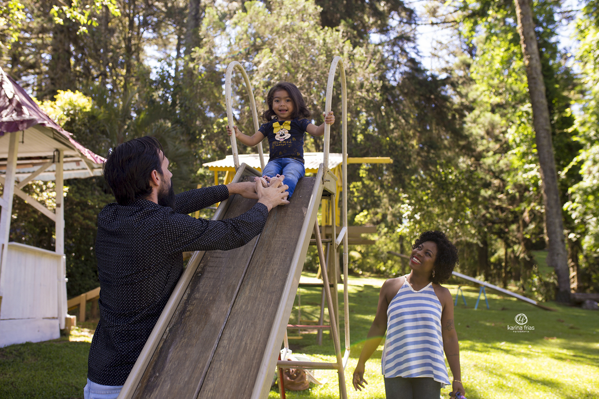os pais brincam no parquinho com a filha