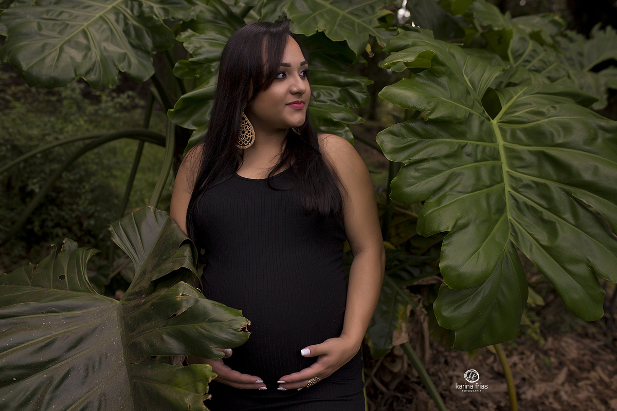 a gestante esta em meio as folhas para suas fotos externas