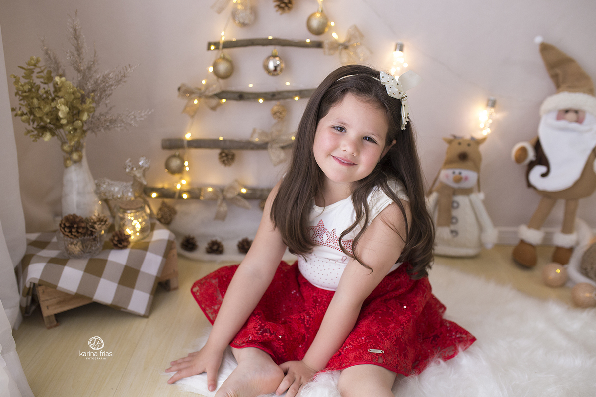 a menina esta sentada no ensaio de natal