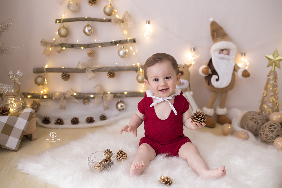 no ensaio infantil, o menino sorri no cenario de natal