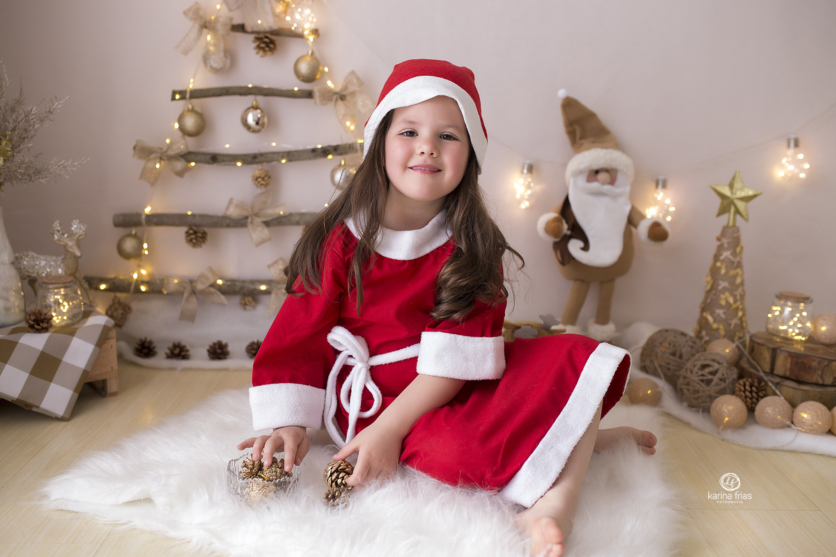 a menina se veste de mamae noel para as fotos de natal