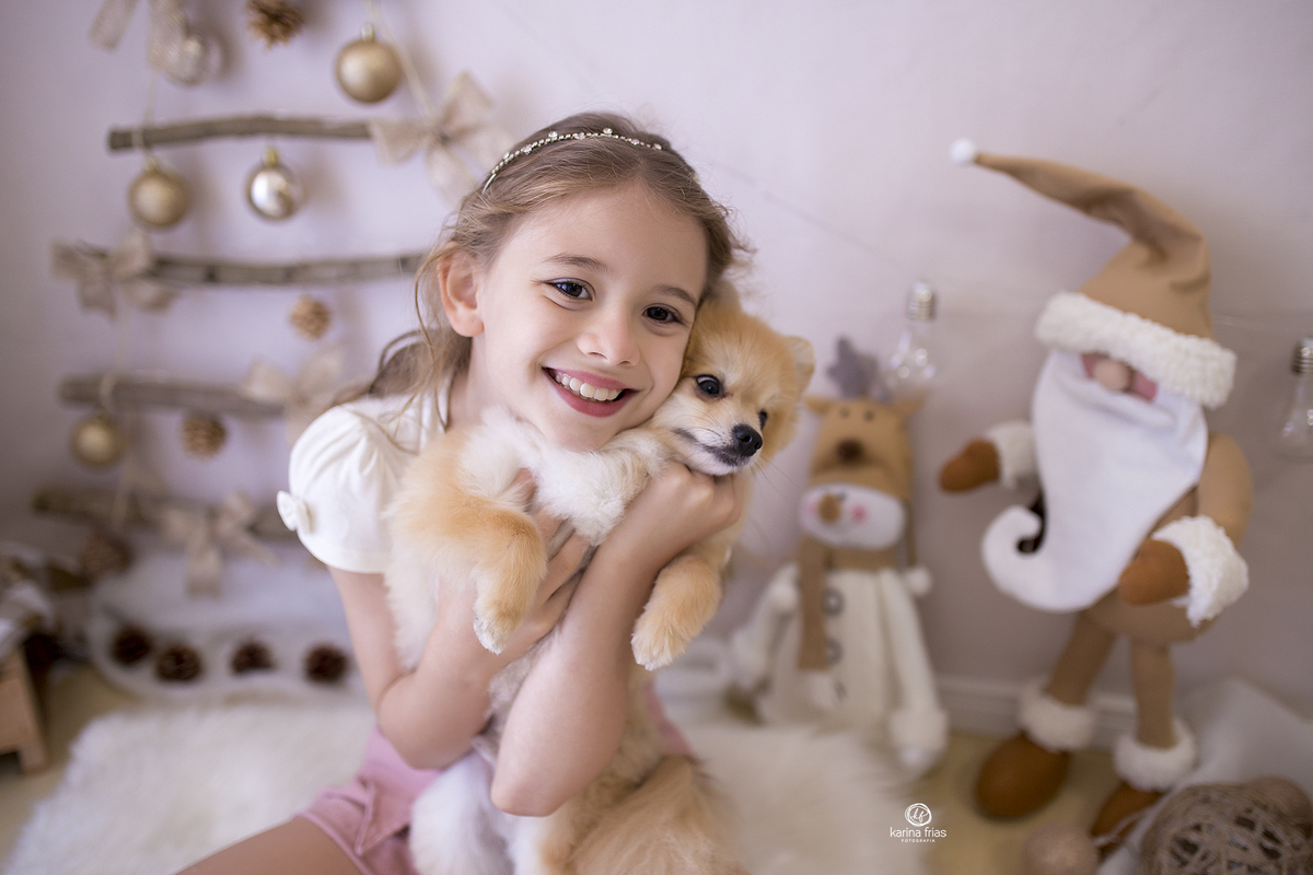 a menina abraça o cachorro na sessão de fotos