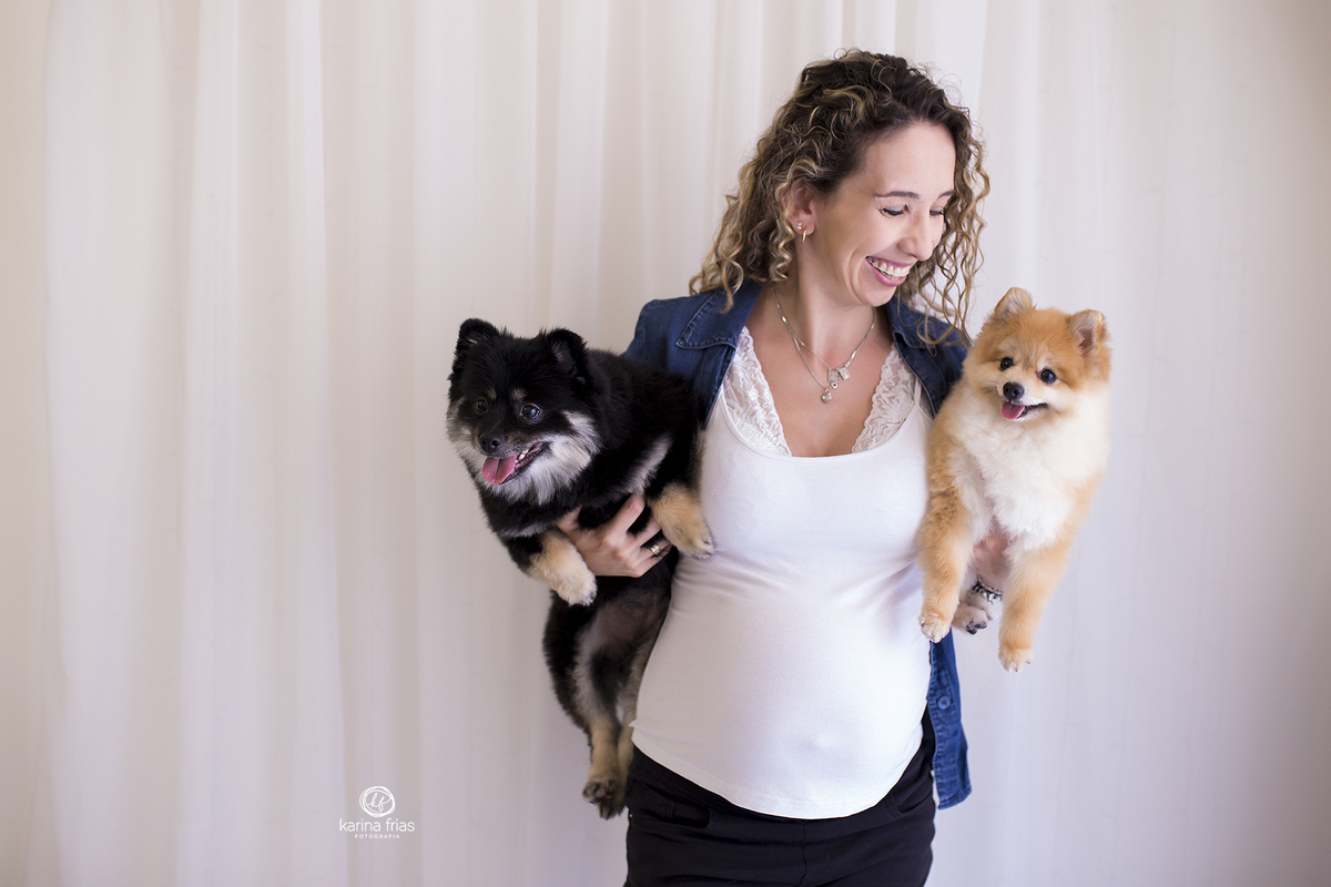 a mae segura os cachorros no colo na sessão de gestante em estudio
