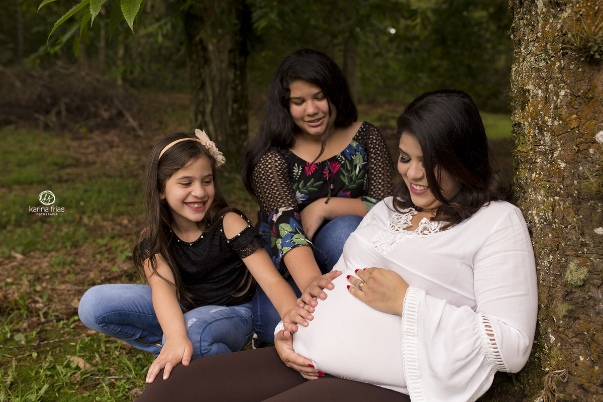 no ensaio de gestante, as filhas posam com a mae