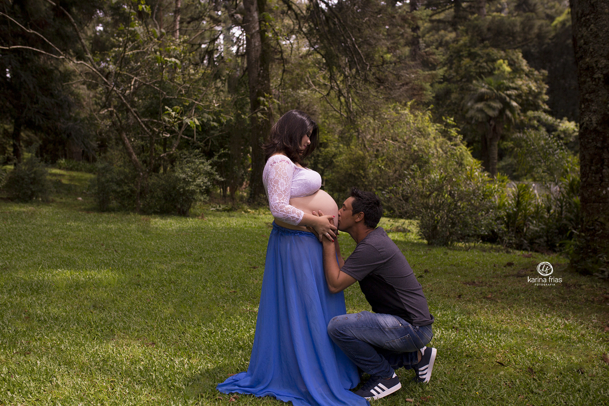 o pai beija a barriga da mae durante a sessão de fotos