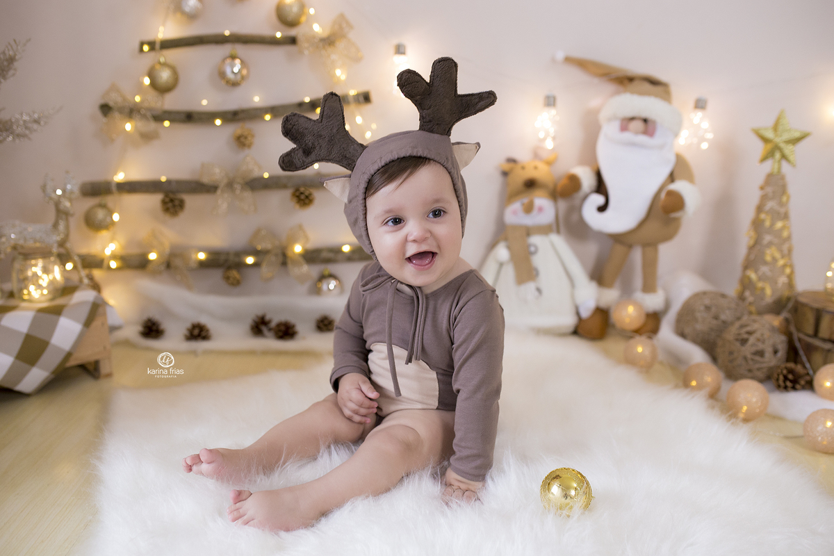 o bebe esta sentado no cenario de natal 