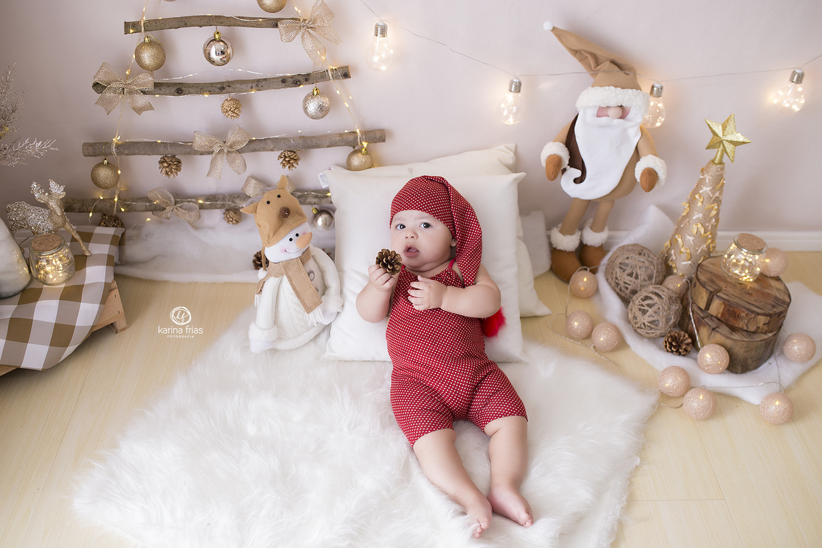 o bebe esta deitado no cenario de natal