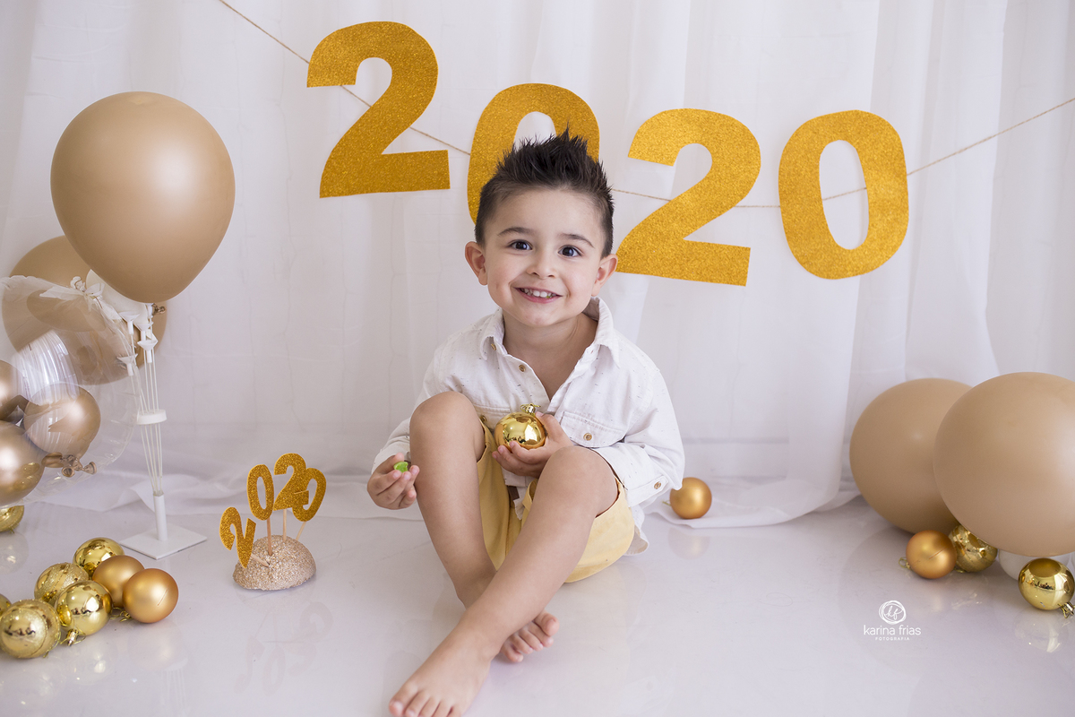 o menino esta sentado no cenario de ano novo