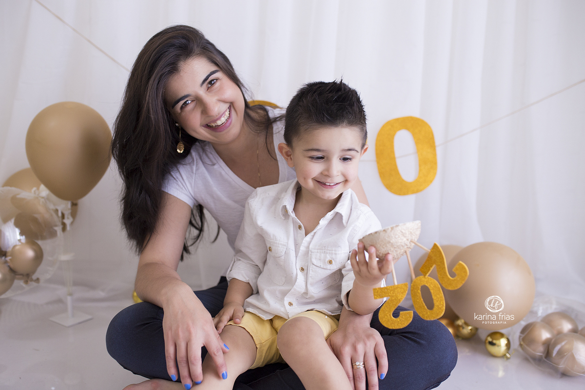 a mae segura o filho no colo para a sessão de fotos