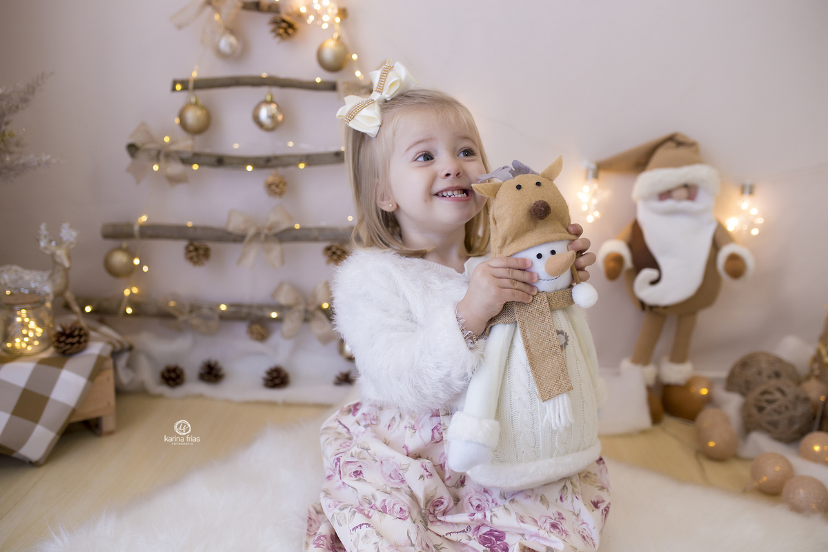 a menina esta sentada no cenario de natal