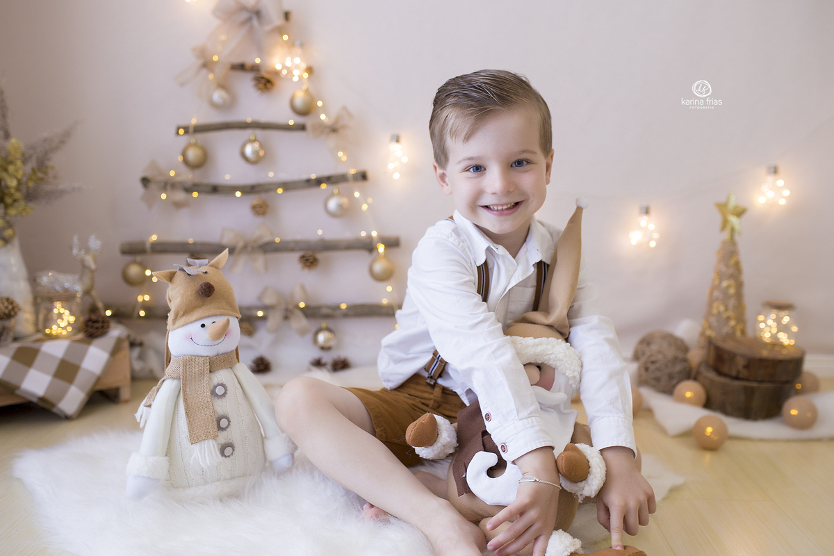 no ensaio infantil, o menino olha para a fotografa de familia de caxias do sul, karina frias