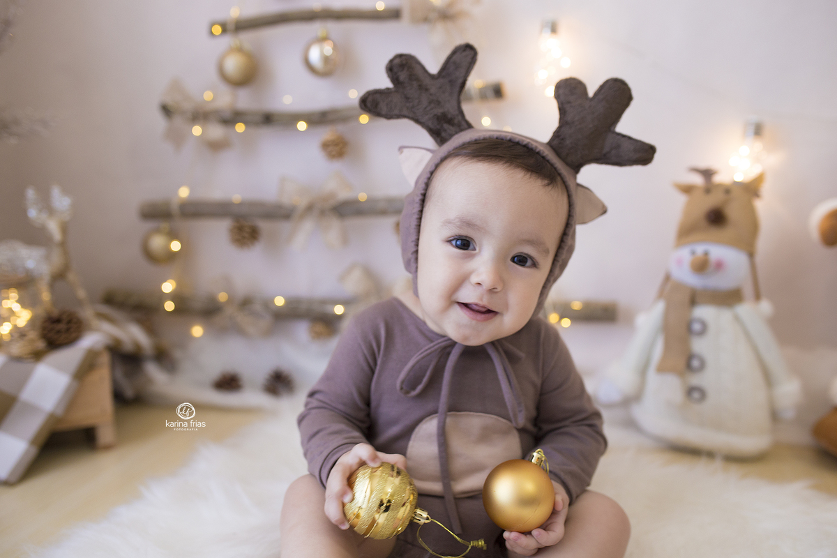 o bebe esta vestido de rena nas fotos do acompanhamento mensal