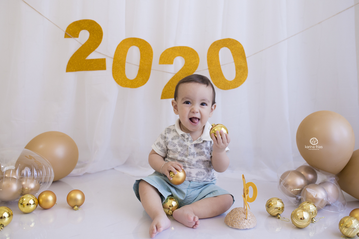 o bebe brinca com a bola de natal no ensaio infantil