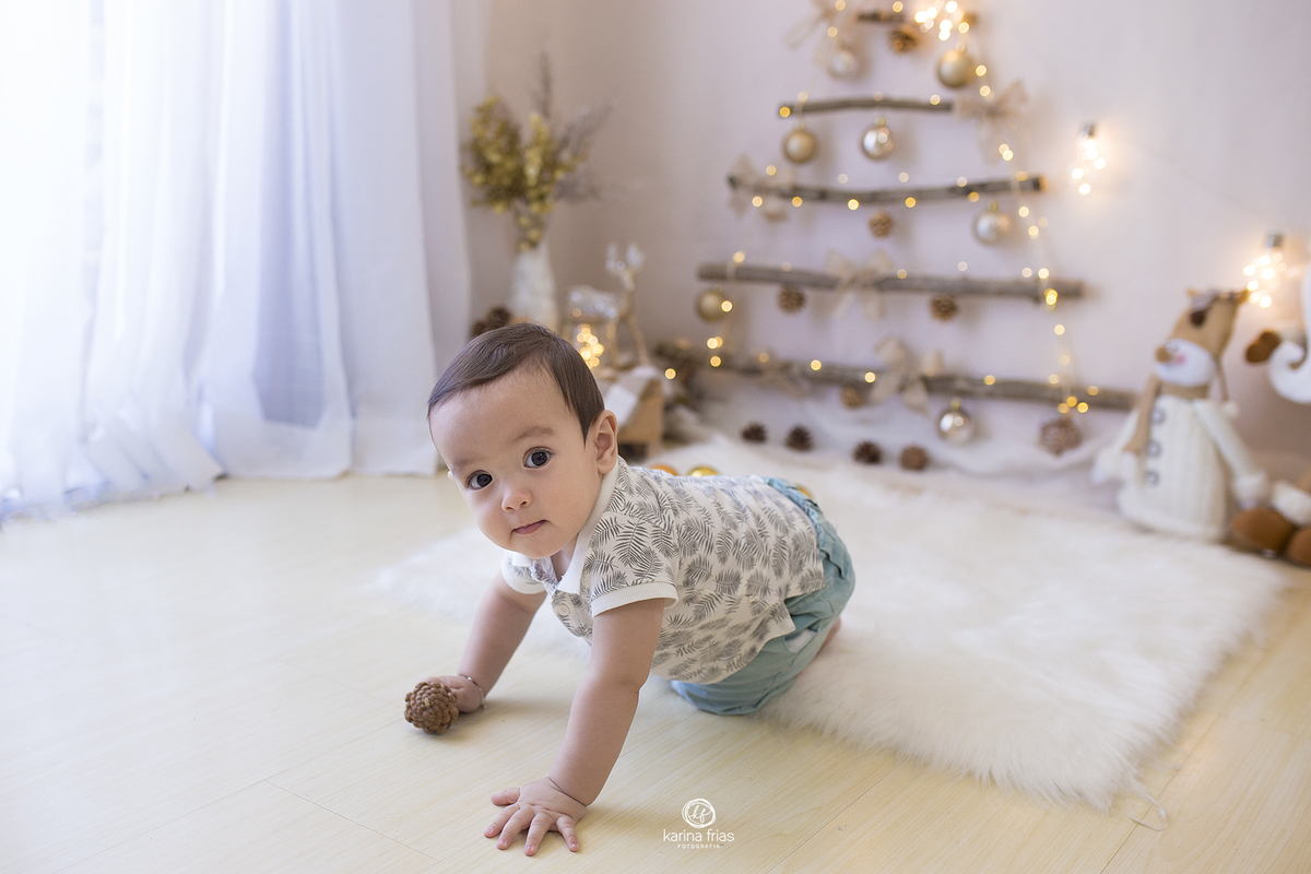 o menino engatinha durante a sessão de fotos mensais