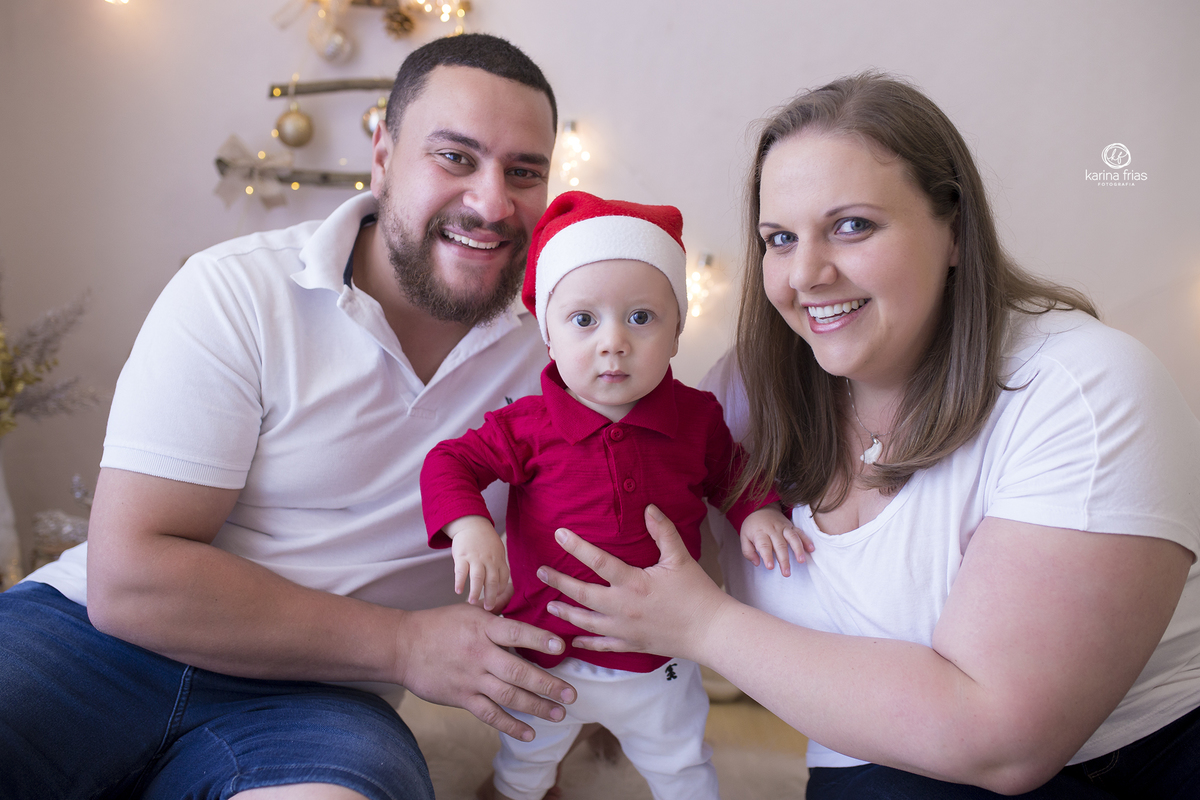 os pais posam com o filho na sessão de fotos
