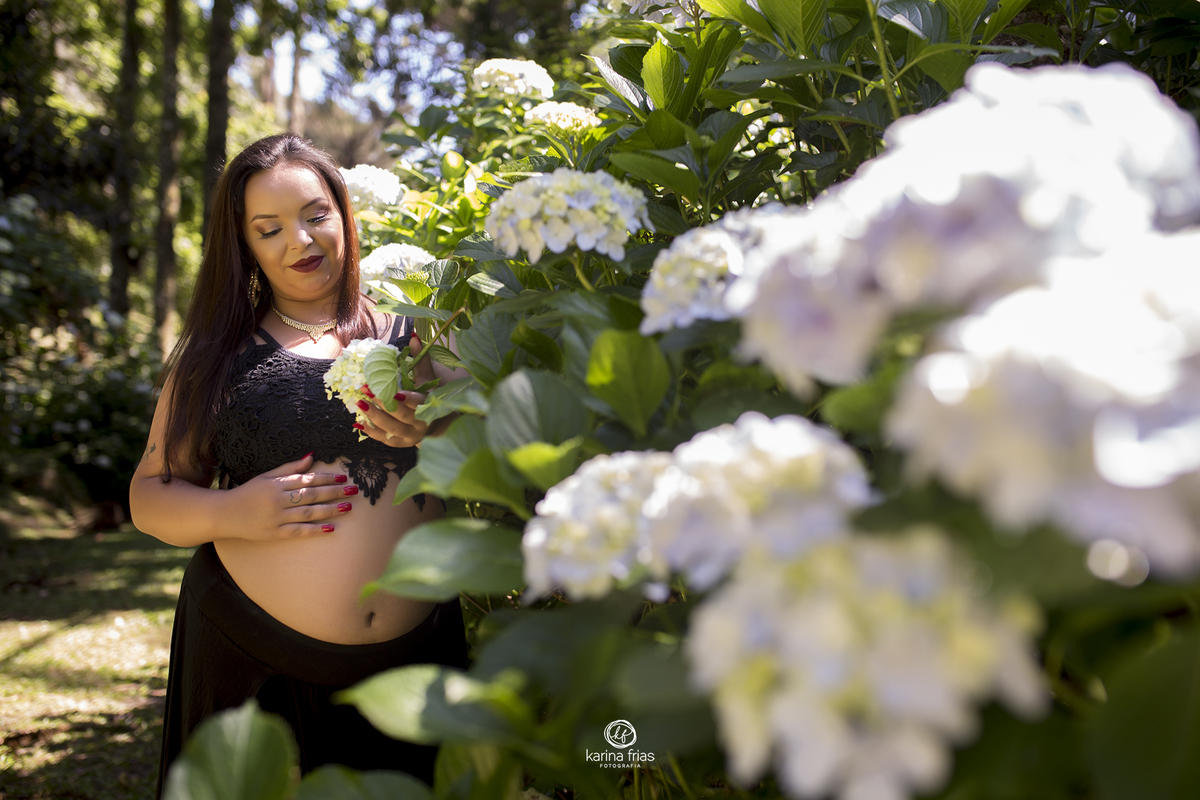 a gestante olha as flores no ensaio externo