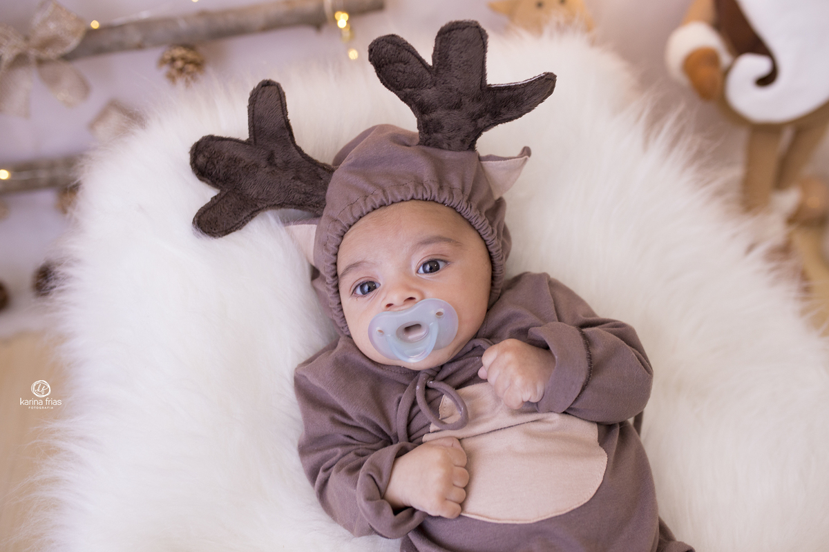 o bebe esta vestido de rena para as fotos do seu acompanhamento