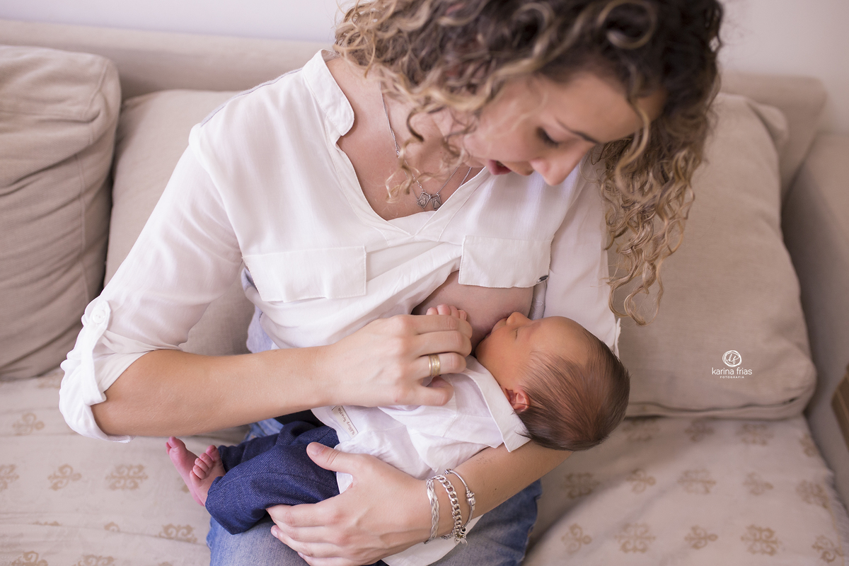 a mãe amamenta o filho na sessão de fotos em familia