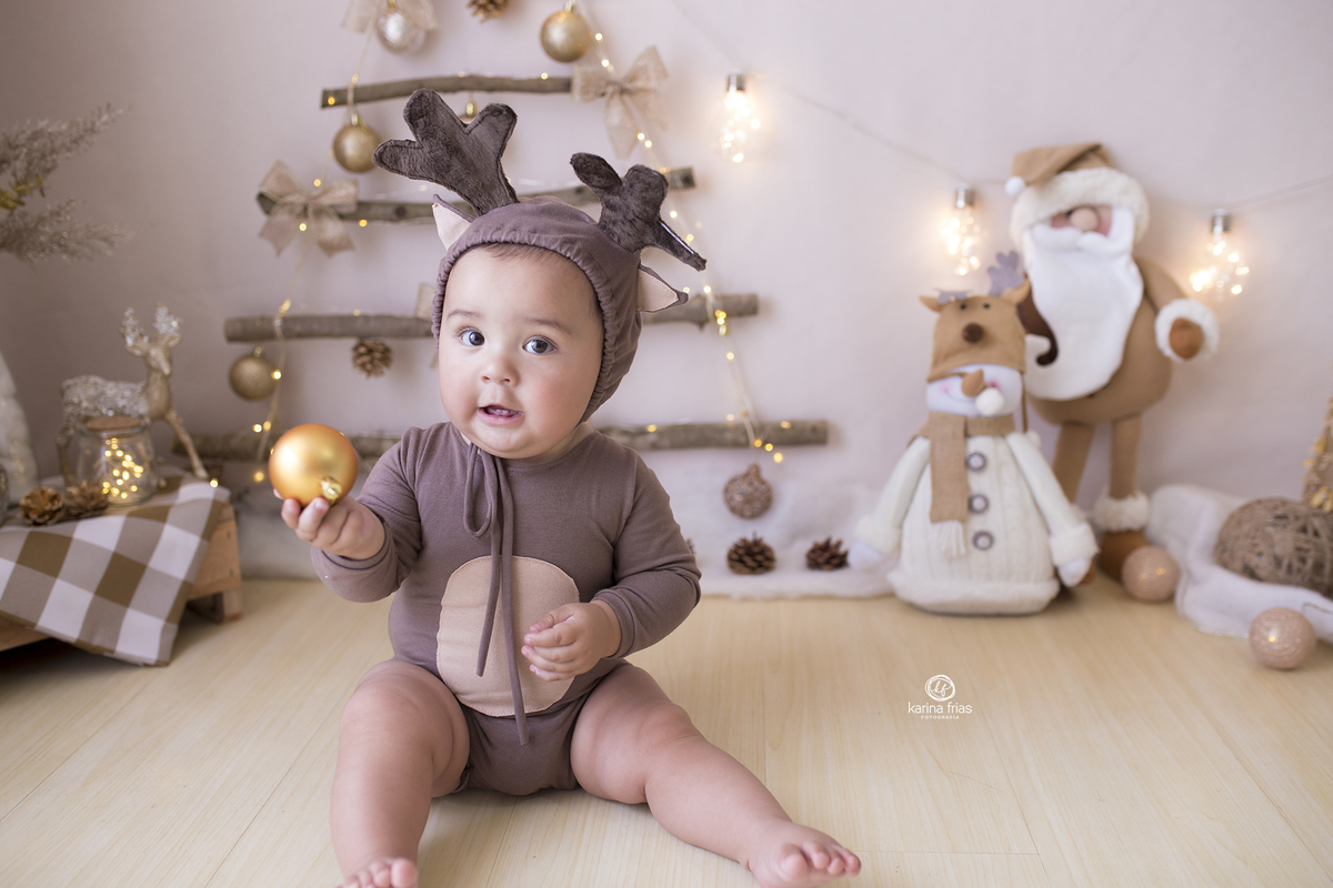 o menino segura a bola de natal durante o ensaio em estudio