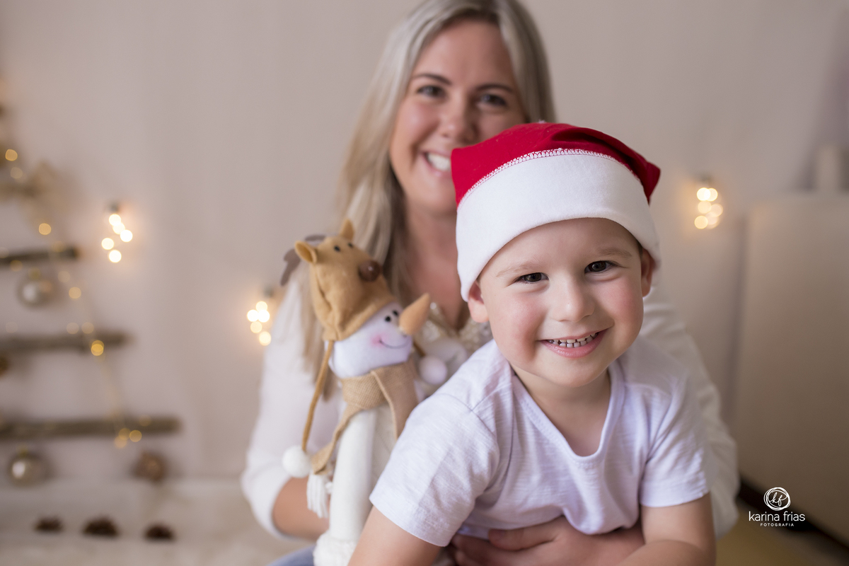 o menino esta no colo da mae enquanto a fotografa de caxias do sul registra o momento