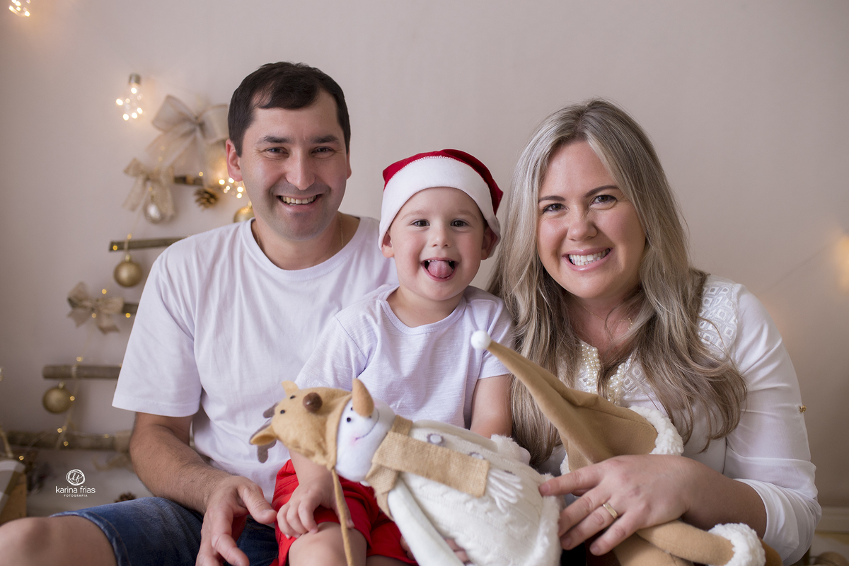 os pais posam com o filho nas fotos em familia