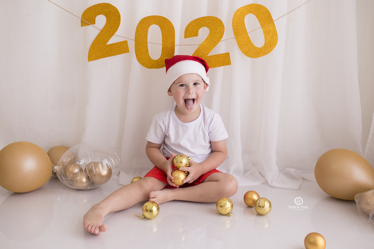 o menino mostra a lingua no cenario de ano novo