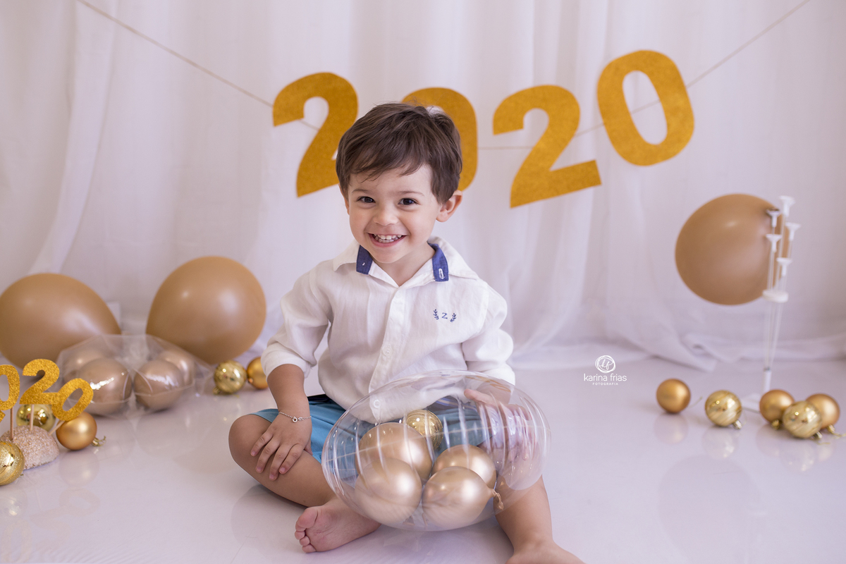 o menino esta sentado no cenario de ano novo