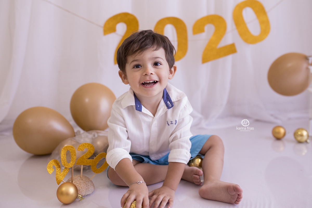 no ensaio infantil o menino olha para a fotografa de familia karina frias