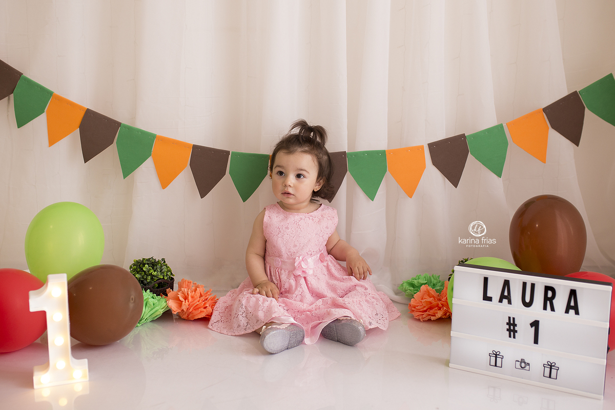 a menina posa para as fotos de um aninho