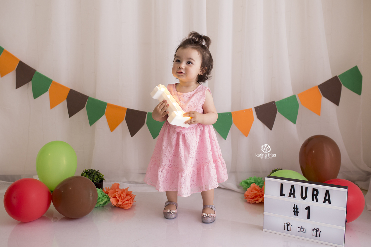 a menina segura o numero na sessão de fotos