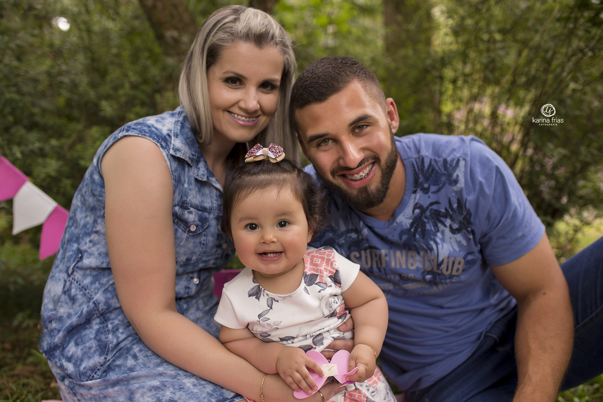 no ensaio em familia, os pais posam com a filha