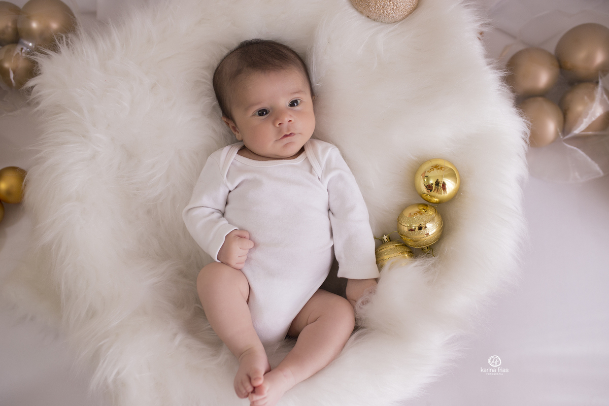 o menino esta deitado para as fotos do acompanhamento mensal