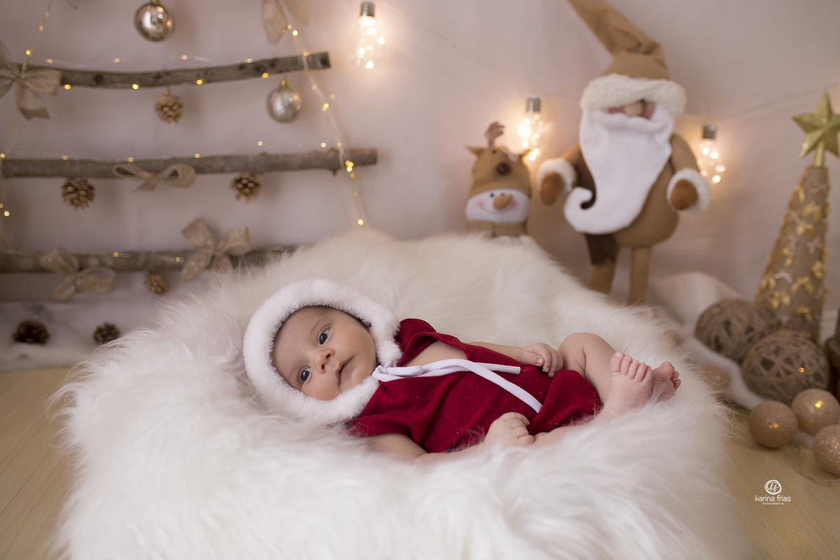 o bebe esta no cenario de natal para sua sessão de fotos