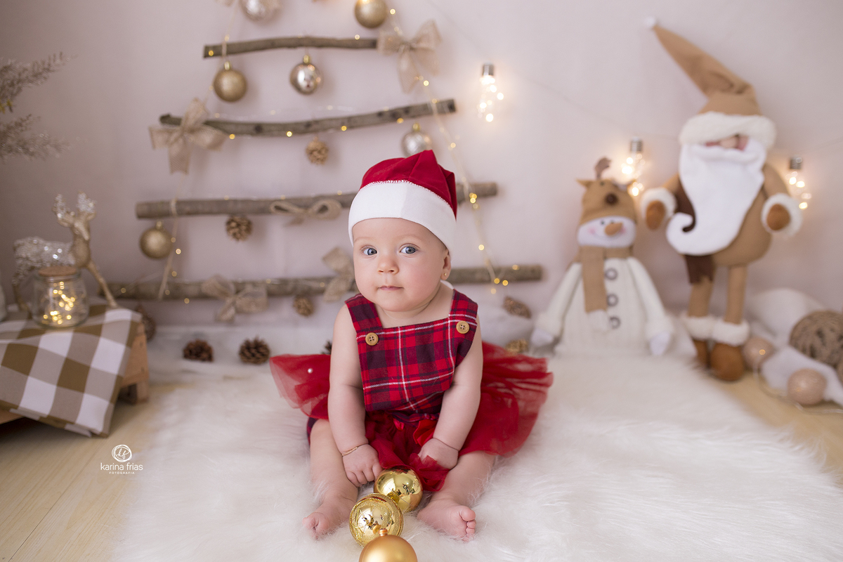 a menina esta sentada no cenario de natal