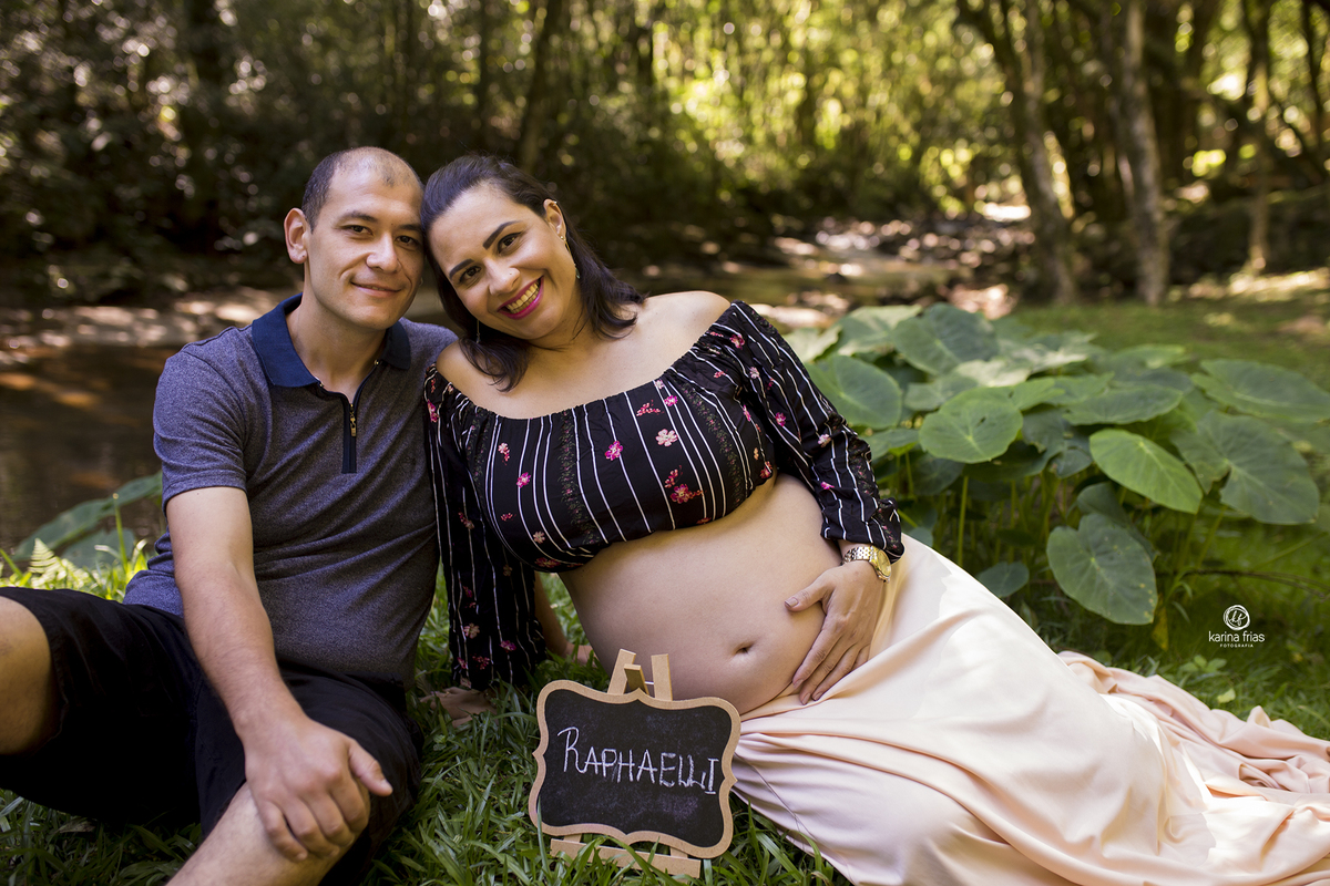 os pais estao sentados a beira do rio para as fotos em caxias do sul-rs