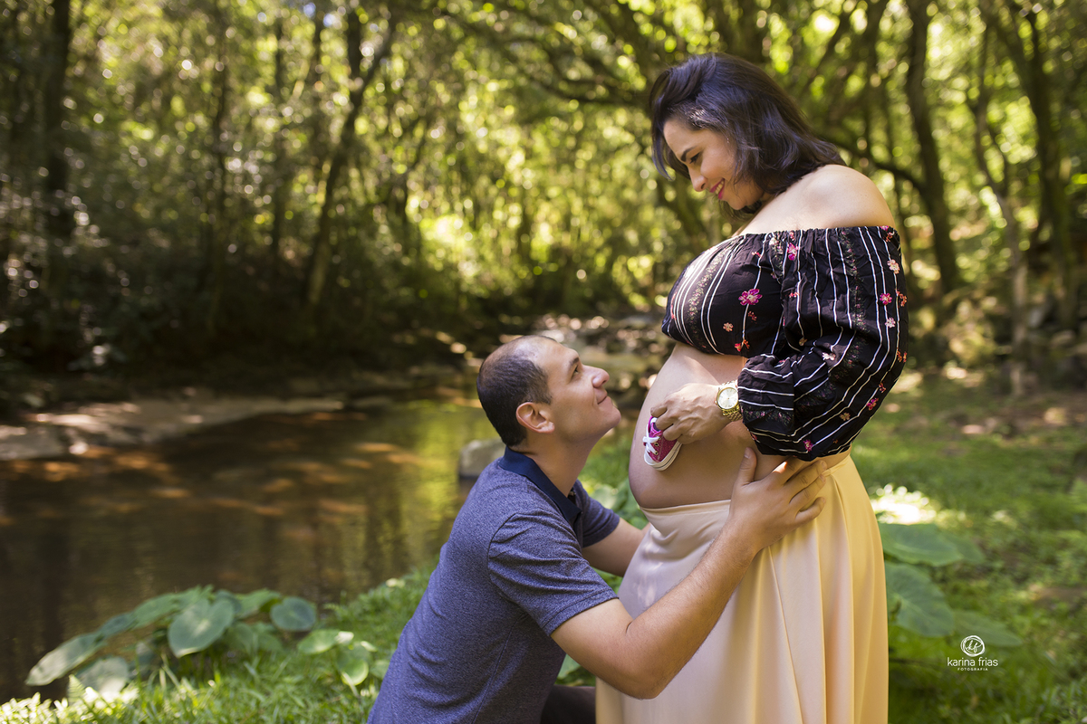 o pai se ajoelha na frente da barriga da mae