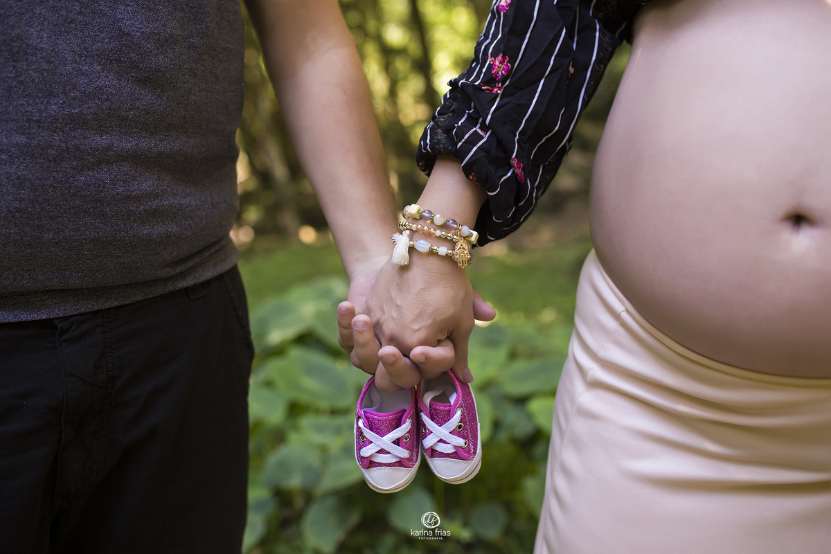 os pais dao as maos e seguram os sapatinhos da bebe