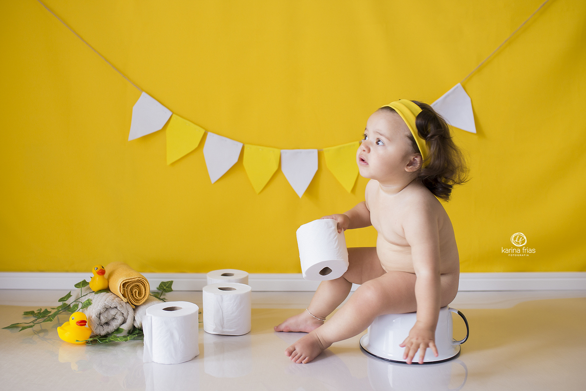 a bebe esta sentada no pinico para as fotos infantis