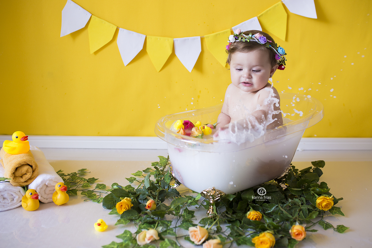 a bebe brinca com a agua da banheira no ensaio infantil em caxias so sul-rs