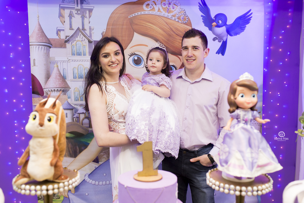 os pais posam com a filha na festa de aniversario