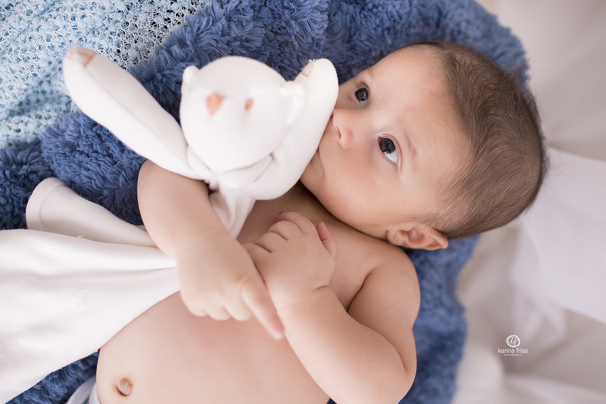 o bebe abraça seu ursinho enquanto a fotografa de caxias do sul registra o momento