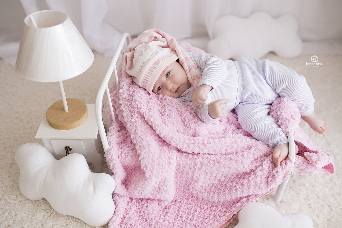 a menina brinca na cama durante sessão de fotos infantis