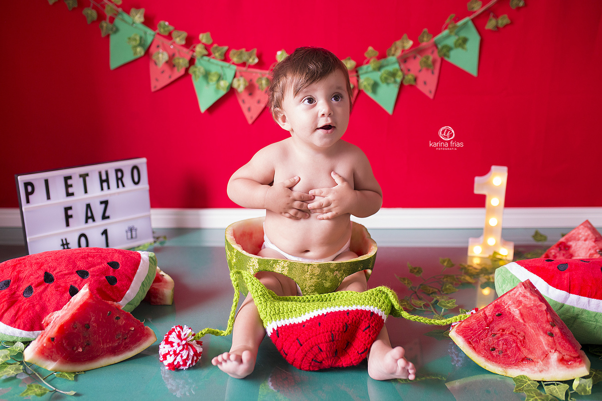 o bebe sorri durante a sessão de fotos de um aninho