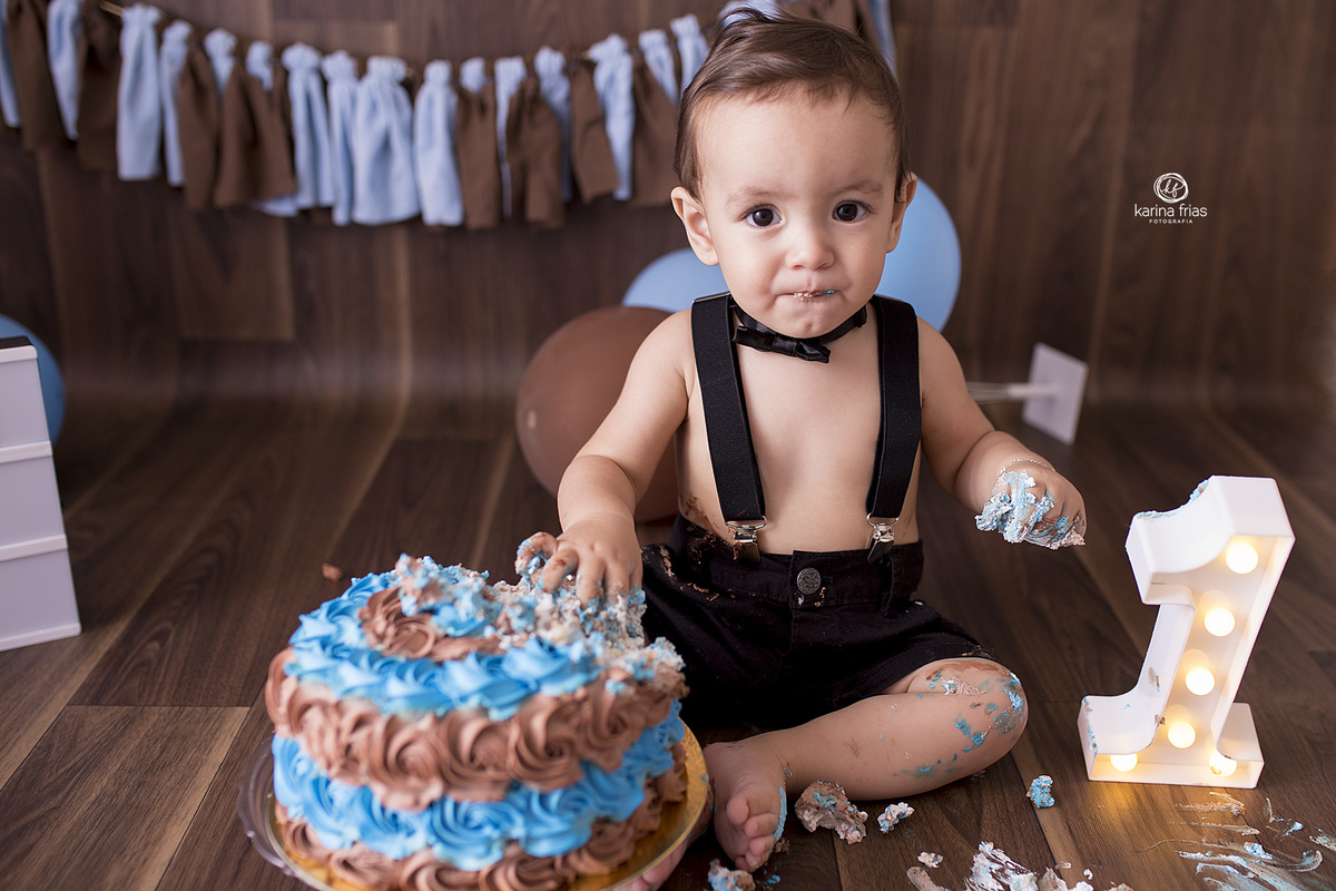 o bebe mexe no bolo durante ensaio infantil