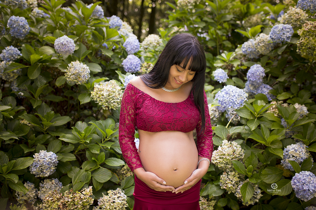 a gestante olha para a barriga durante ensaio fotografico