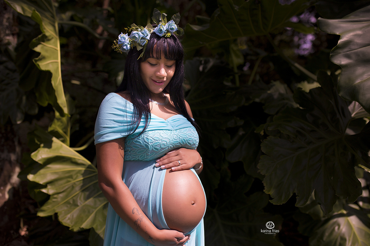 no ensaio de gestante, a mae olha para a barriga