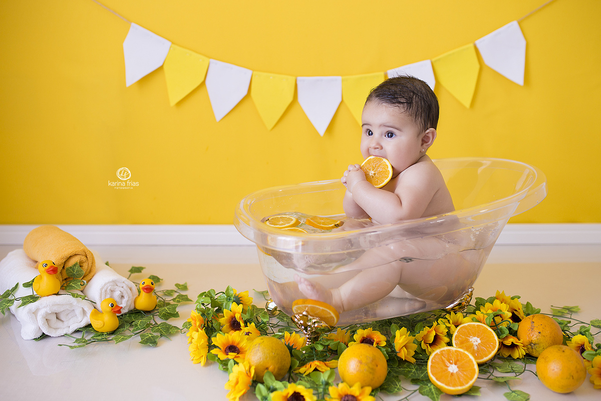 a menina brinca com as laranjas da banheira